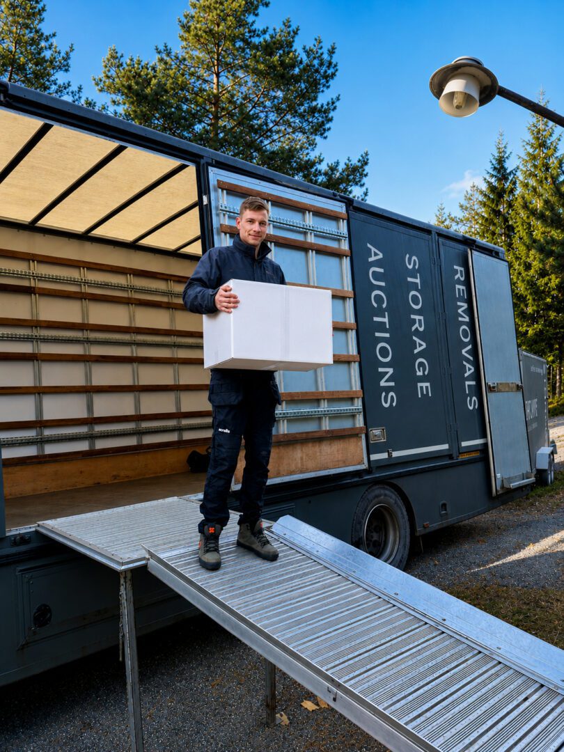 Man carrying box down moving truck ramp