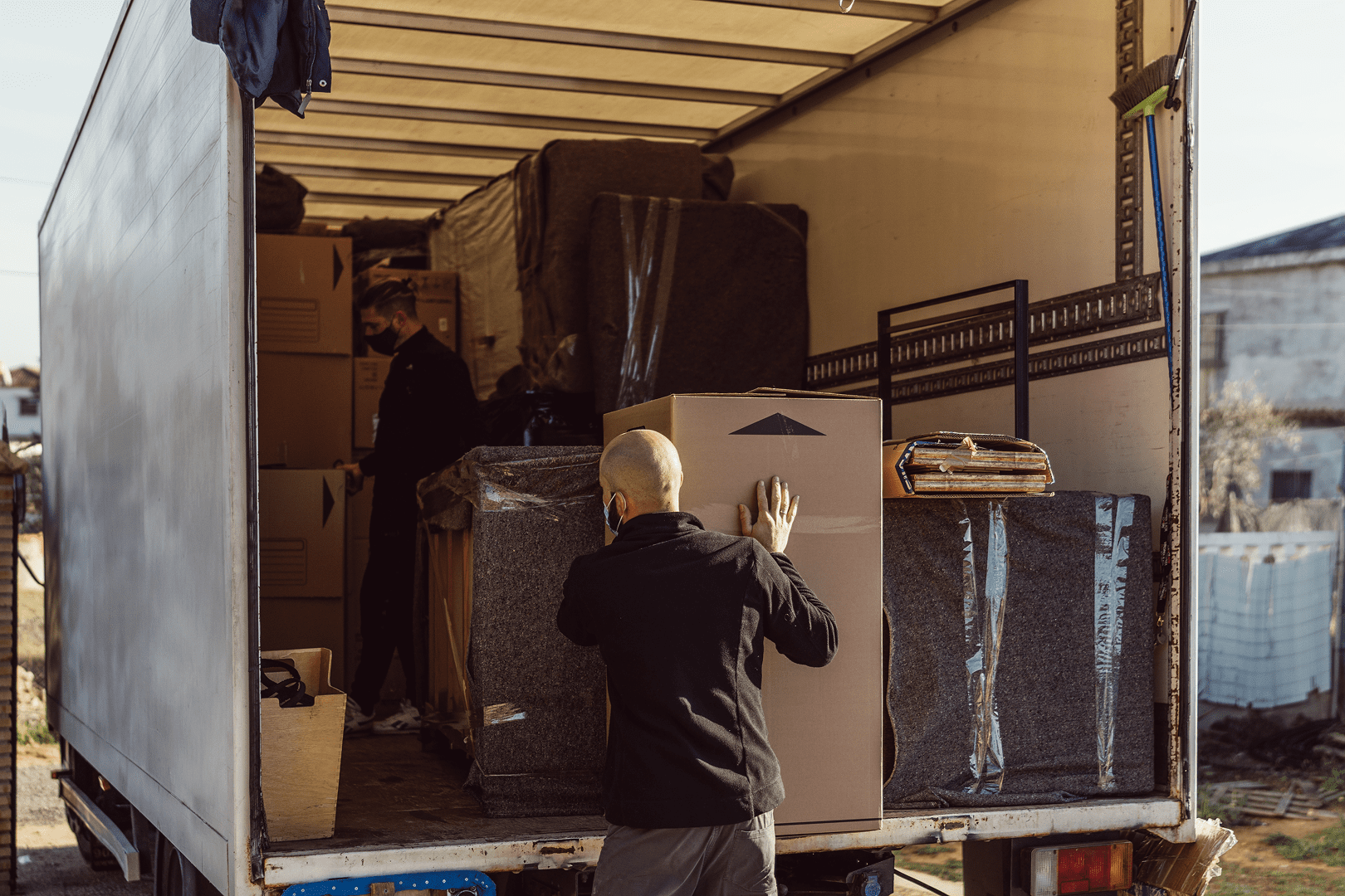 Person loading moving truck with boxes and furniture