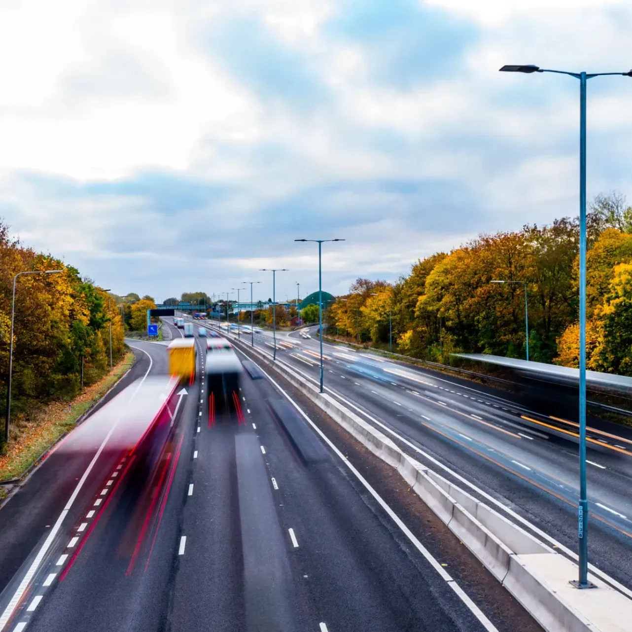Blurred traffic on motorway with autumn trees